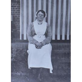 Unidentified woman sitting on a brick wall
