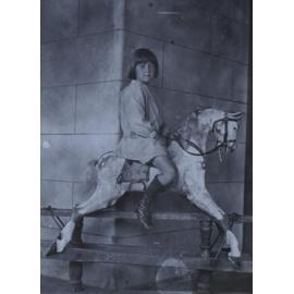 Unidentified young girl on a rocking horse