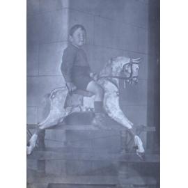 Unidentified young boy on a rocking horse
