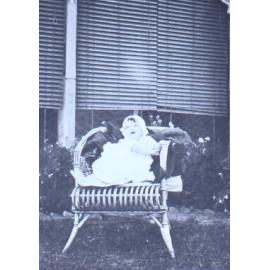 Baby sitting in a chair on the lawn