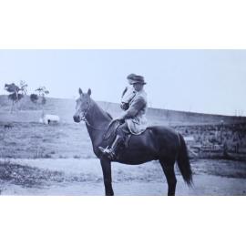 Man holding a child on a horse