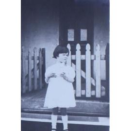Young girl standing outside a house