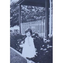Young girl standing near a flower bed