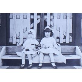 Two young girls sitting on a step