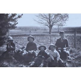 Group of children sitting near a fence