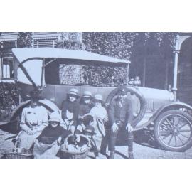 Group of children and an woman sitting on a car