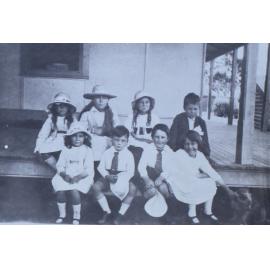 Group of children sitting on the verandah steps