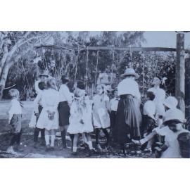 Group of children trying to eat apples on strings