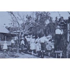 Group of children trying to eat apples on strings
