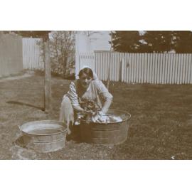 Unidentified woman giving a pet dog a bath
