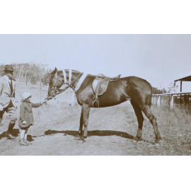 Unidentified man, girl and saddled horse