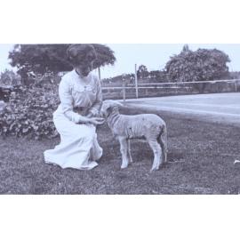 Woman and pet lamb on the lawn