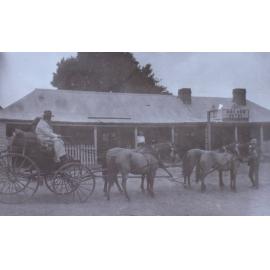 Four horses pulling a buggy in front of the Anchor Hotel