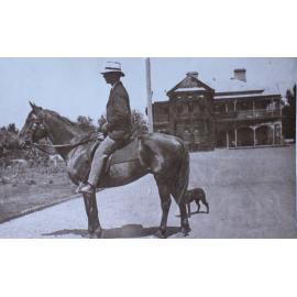 Man on a horse with a pet dog