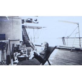 Woman and soldier reading onboard a ship