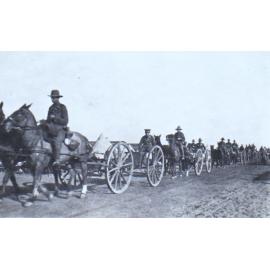 Soldiers on horseback pulling gun carriages