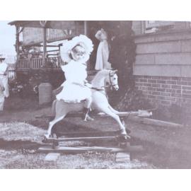 Young girl riding a rocking horse