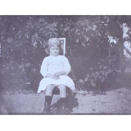 Young girl sitting on a chair in the garden