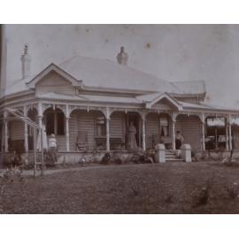 House with two women and a child on the verandah