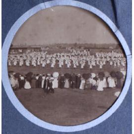 Crowd watching a large group of girls/young women doing exercises