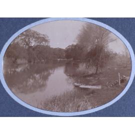 View of a river with a small boat at the edge and steps down the bank to the boat