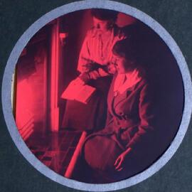 Two women sitting by a radiator