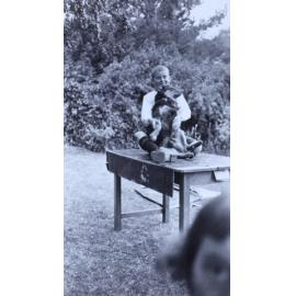 Boy sitting on a table with a pet dog