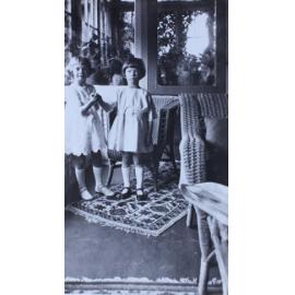 Two young girls standing in a sunroom