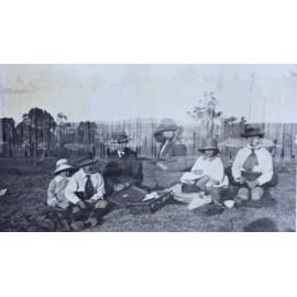Woman and five children on a picnic