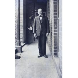 Man standing on a narrow verandah