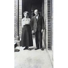 Man and a woman standing on a narrow verandah