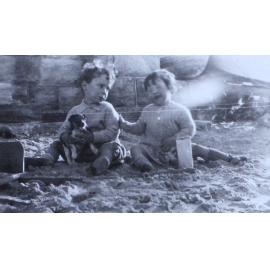 Jill on the beach with another child and pet puppy