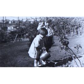 Jill with another child watering the garden