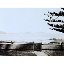 View of beach beyond a picket fence