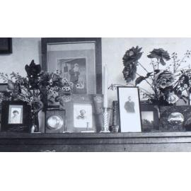 Top of a cabinet with photographs and flowers
