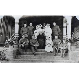 Group of soldiers and nurses sitting on the steps of Saumarez