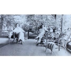 Two unidentified women sitting on a verandah