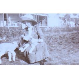 Unidentified woman with two pet lambs