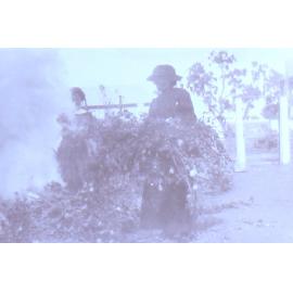 Unidentified women in garden burning garden clippings