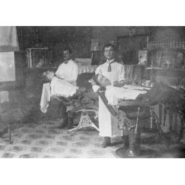 Joe Correy inside his barber shop in Glen Innes, about 1908