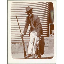 Man holding rifle and rabbit
