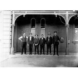 Six men on railway station verandah