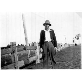 Mr Barry standing beside a post and rail fence, c. 1930