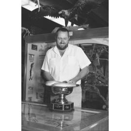 Unidentified man with snake in Armidale Gold Cup trophy, University of New England Natural History Museum, 1993
