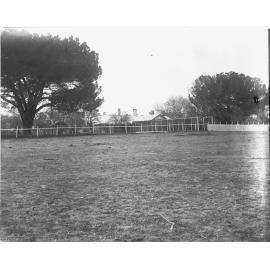 View of a paddock with a house in the background