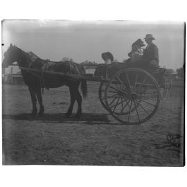 Family sitting in a horsedrawn wagon