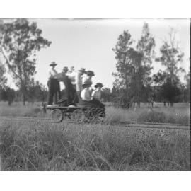 Group of six riding a hand-operated railway trolley
