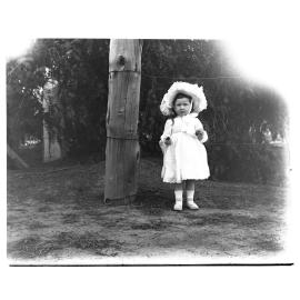 A small girl standing outside holding strawberries