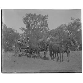 Two women and two children in a carriage pulled by four horses