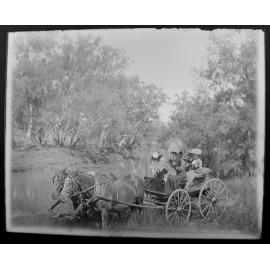 Family in horse drawn wagon by a watercourse, 1905